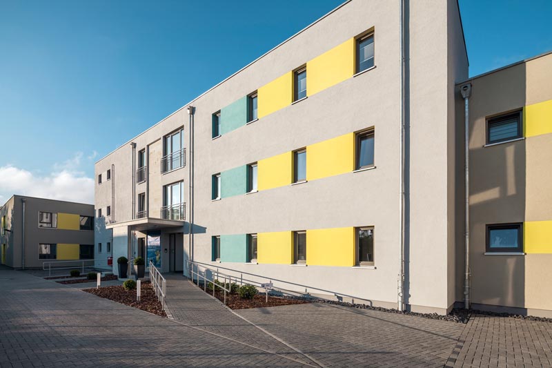 Bunte Putzfassade bei Seniorenwohnheim aus Holz