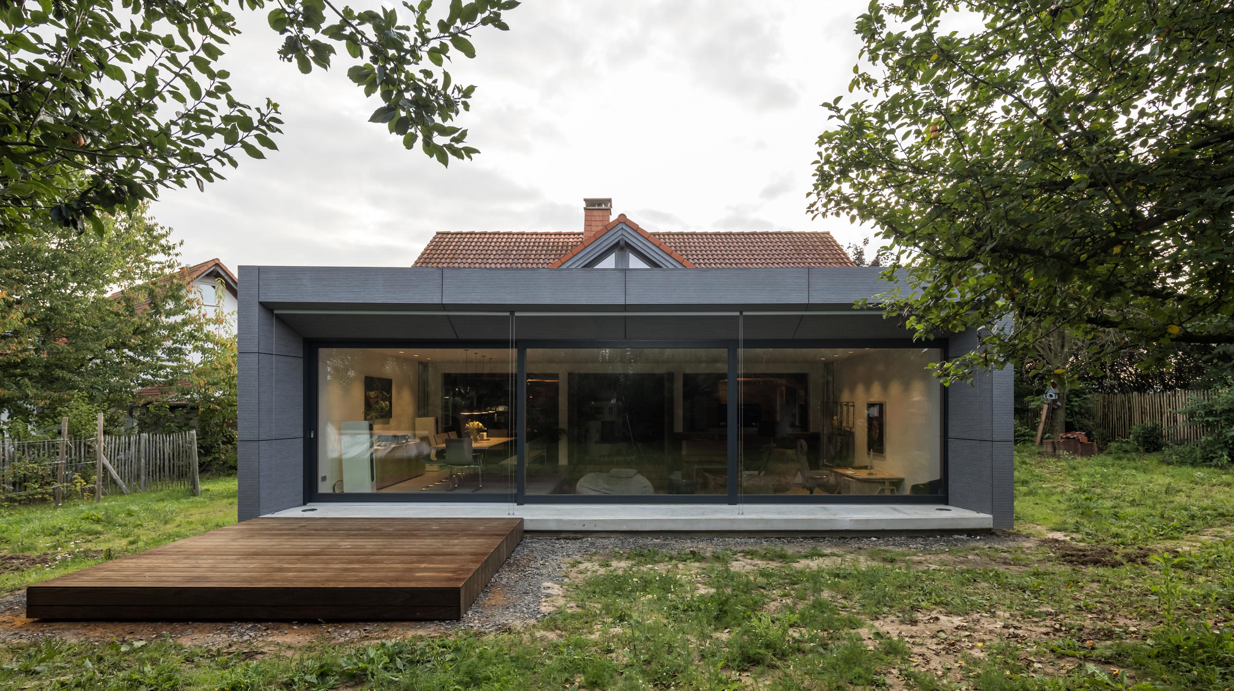 Anbau mit großer Fensterfront und Holzterrasse